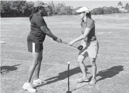  ?? STEVE WATERS/STAFF PHOTO ?? Teaching pro Connie Capanegra of The First Tee of The Palm Beaches helps veteran Pamela Carithers, left, with a swing training aid during a practice session.