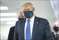  ?? PATRICK SEMANSKY - THE ASSOCIATED PRESS ?? President Donald Trump wears a mask as he walks down the hallway during his visit to Walter Reed National Military Medical Center in Bethesda, Md., Saturday, July 11.