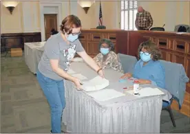  ?? Doug Walker ?? Floyd County Board of Elections member Melanie Conrad (from left) brings a fresh stack of ballots to Becky Diamond and Deborah Ward on Saturday, Nov. 14, during the hand recount of ballots in the 2020 presidenti­al election.