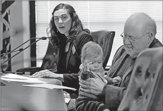  ?? [CHRIS DORST/ CHARLESTON GAZETTE-MAIL] ?? Lindsay Pace, left, of Chattanoog­a, Tenn., testifies while retired coal miner Stanley Sturgill of Lynch, Ky., holds Pace’s son, Theo, during an Environmen­tal Protection Agency hearing Tuesday in Charleston, W.Va.