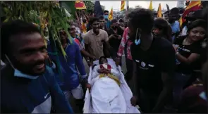  ?? (AP/Eranga Jayawarden­a) ?? Protesters carry a mock coffin of prime minister Mahinda Rajapaksa outside parliament during a countrywid­e strike Friday in Colombo, Sri Lanka.