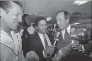  ?? Associated Press ?? NFL Commission­er Pete Rozelle, right, presents the Super Bowl XV trophy to Oakland Raiders managing general partner Al Davis, left, in 1981. Sportscast­er Bryant Gumble holds the microphone at center.