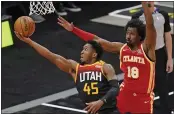  ?? RICK BOWMER — THE ASSOCIATED PRESS ?? Jazz guard Donovan Mitchell (45) lays the ball up as Hawks forward Solomon Hill (18) defends on Friday.
