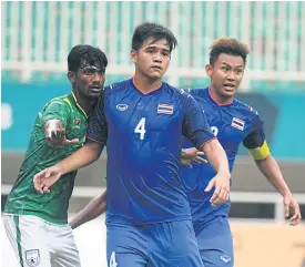  ??  ?? Thailand defender Worawut Namvech, No.4, and Chenrop Samphaodi during the match against Bangladesh.