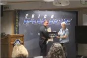 ?? ?? Chico police chief Matthew Madden presents former Chico police Lt. Linda Dye with three badges at the Chico Fire Training Center in Chico on Thursday. The badge replaces three that she lost in the 2018Camp Fire.
