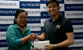  ??  ?? Connie Kalagayan, the executive director of the Inquirer Foundation, receives the donation from Raphael Layosa, governor of Pan Xenia Fraternity of the University of the Philippine­s Diliman.