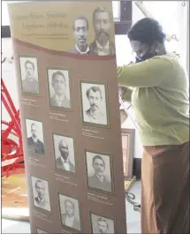  ?? Brodie Johnson • Times-Herald ?? The St. Francis County Museum’s exhibit on African-American Legislativ­e members in Arkansas will continue to the end of this week. Museum employee Rosalee Johnson sets up one of the banners as the museum opens this morning.