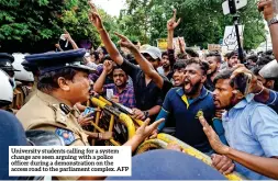  ?? ?? University students calling for a system change are seen arguing with a police officer during a demonstrat­ion on the access road to the parliament complex. AFP