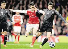  ??  ?? Für dieses Foul im Strafraum an Robert Lewandowsk­i (r.) sah Arsenals Laurent Koscielny Rot - sehr strittig!