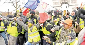  ??  ?? Protesters wearing ‘yellow vest’ (gilet jaune) gesture near the Arc de Triomphe in Paris. — AFP photo