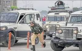  ?? AP ?? ■ A security personnel rushes towards the encounter site in central Srinagar on Tuesday.