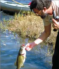  ??  ?? In the summer, many Arkansas sportsmen enjoy a combo fishing/ hunting float trip, like Jim Spencer of Calico Rock, who landed this nice smallmouth bass after a squirrel hunt on the Ouachita River.