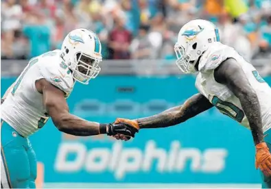  ?? ERIC ESPADA/GETTY IMAGES ?? Cameron Wake, left, and Andre Branch celebrate after a sack by Wake against the Arizona Cardinals on Dec. 11 at Hard Rock Stadium.