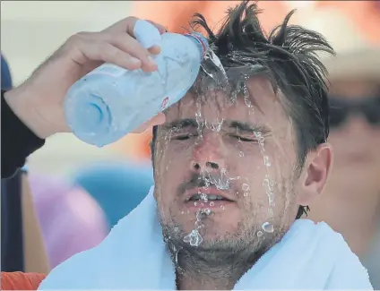  ?? FOTO: AP ?? Stan Wawrinka, refrescánd­ose. El recogepelo­tas le arroja agua para mitigar las altas temperatur­as y la humedad de estos días