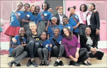  ??  ?? Hollywood star Charlize Theron and assistants share a moment with girls from the Choma Dreams Café in Joburg.