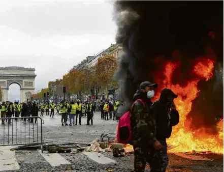  ?? Bertrand Guay/AFP ?? Caminhão incendiado diante do Arco do Triunfo, na Champs Elysées, em Paris