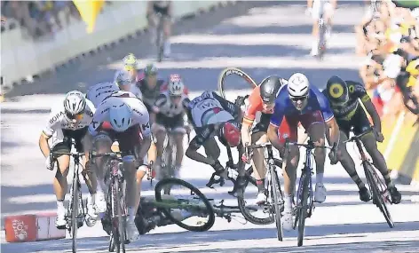  ?? FOTO: DPA ?? Abgeräumt: Mark Cavendish liegt schon auf dem Boden, sein britischer Landsmann Ben Swift fliegt kopfüber auf den Asphalt. Ganz links Peter Sagan, der den Sturz mit seinem gefährlich­en Fahrstil ausgelöst hatte.