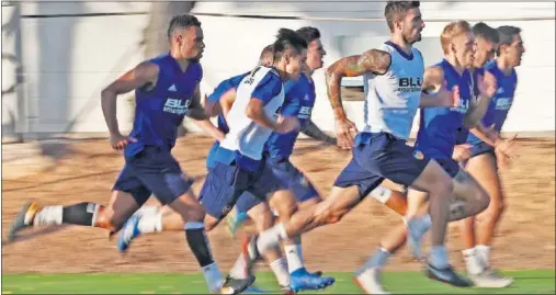  ??  ?? ESFUERZO. El Valencia regresó ayer a los entrenamie­ntos con una sesión exigente dirigida por Marcelino.