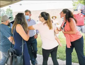  ?? Dave Zajac / Associated Press ?? Gov. Ned Lamont, center, and staff leave Highland Elementary School Wednesday in Cheshire, as protesters follow them to their vehicle after a roundtable with education stakeholde­rs and public health officials.