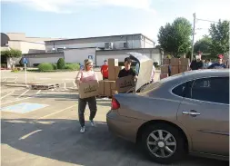  ?? Staff photo by Greg Bischof ?? ■ Volunteers load a car with food at First Baptist Church on Moores Lane in Texarkana.