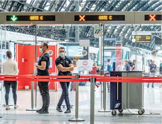  ??  ?? In Lombardia Il bacio di una giovane coppia di fronte alle porte di accesso e uscita dai binari della Stazione Centrale di Milano (Imagoecono­mica)