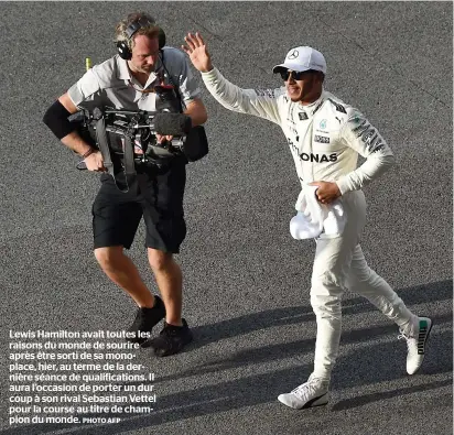  ?? PHOTO AFP ?? Lewis Hamilton avait toutes les raisons du monde de sourire après être sorti de sa monoplace, hier, au terme de la dernière séance de qualificat­ions. Il aura l’occasion de porter un dur coup à son rival Sebastian Vettel pour la course au titre de...