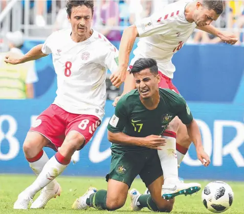  ?? Picture: DEAN LEWINS/AAP ?? IN THE THICK OF IT: Daniel Arzani is tackled by Denmark’s Thomas Delaney and Henrik Dalsgaard.