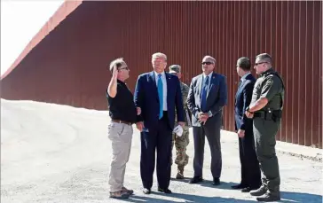  ??  ?? Huge barrier: Trump visiting the section of the US-Mexico border wall in Otay Mesa in San Diego, California. — Reuters