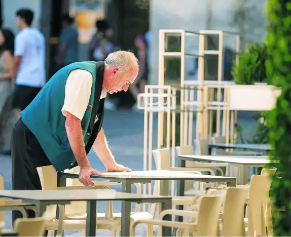 ?? CAM ?? Un trabajador ordenando las mesas de una terraza en Madrid
