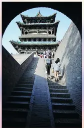  ?? ZHANG WEI / CHINA DAILY ?? Visitors negotiate the steps up to the city walls of Pingyao.