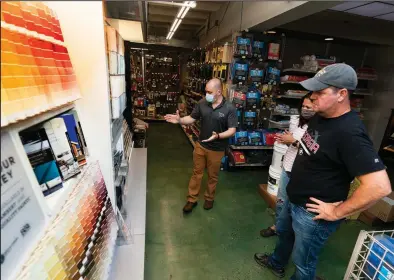  ?? (AP/Manuel Balce Ceneta) ?? Billy Wommack (left), purchasing director at W.S. Jenks & Sons hardware, works with customer Tim Wood on an outdoor paint color for his house Friday in Washington, D.C.