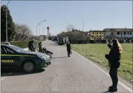  ?? ANDREA MANTOVANI — THE NEW YORK TIMES ?? Alessandra Paladini, right, waves to her mother, Tina Pomati, who lives in the quarantine­d “red area” of Italy’s Lombardy region, after a policeman delivered Paladini’s care package.