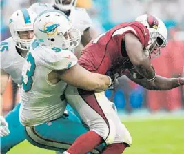  ?? JIM RASSOL/STAFF FILE PHOTO ?? Dolphins defensive tackle Ndamukong Suh brings down Arizona Cardinals running back David Johnson (31) during Miami’s 26-23 victory in December.