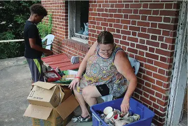  ?? The Sentinel-Record/Courtney Edwards ?? ■ Sheryl Talbert, right, sorts items with her grandchild­ren on Thursday at 121 Grove St. in preparatio­n for the yard sale.