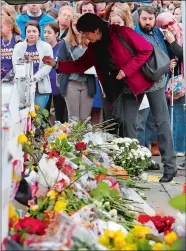  ?? GENE J. PUSKAR/AP PHOTO ?? People pay their respects Thursday at a makeshift memorial outside the Tree of Life Synagogue to the 11 people killed Saturday while worshippin­g in the Squirrel Hill neighborho­od of Pittsburgh.