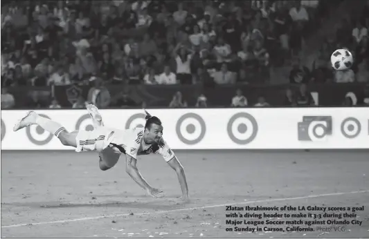  ??  ?? Zlatan Ibrahimovi­c of the LA Galaxy scores a goal with a diving header to make it 3-3 during their Major League Soccer match against Orlando City on Sunday in Carson, California.