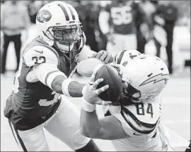  ?? Bill Kostroun Associated Press ?? CHARGERS TIGHT END Sean McGrath, right, and Jets safety Jamal Adams battle for control of the ball during the second half.