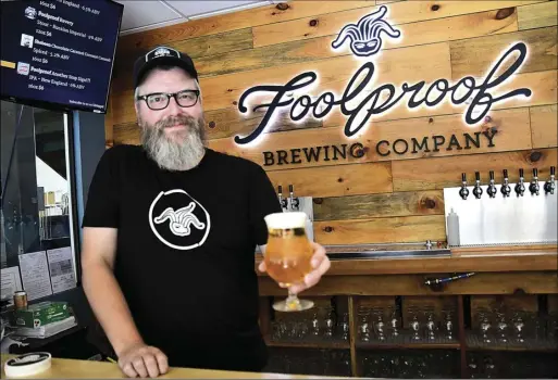  ?? Photos by Ernest A. Brown ?? John Windle, tap room manager at Foolproof Brewing Company, located at 241 Grotto Ave., in Pawtucket, serves an Ocean State Lager at Foolproof last week. The taps will be flowing on Saturday as Foolproof celebrates its 10th annual Augtoberfe­st with live music, food trucks, contests, and plenty of cold beer this Saturday from 5-10 p.m.