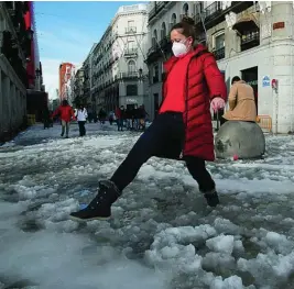  ?? GONZALO PÉREZ ?? Un viandante sortea el hielo y la nieve en la Puerta del Sol de Madrid