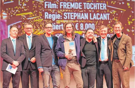  ?? FOTO: GERD MÄGERLE ?? Freuen sich mit Regisseur Stephan Lacant (Mitte) über den Goldenen Biber für „Fremde Tochter“: (v. l.) Tobias Meinhold vom Filmfestve­rein, OB Norbert Zeidler, die Produzente­n Daniel Reich und Christoph Holthof, Filmfest-Intendant Adrian Kutter und...