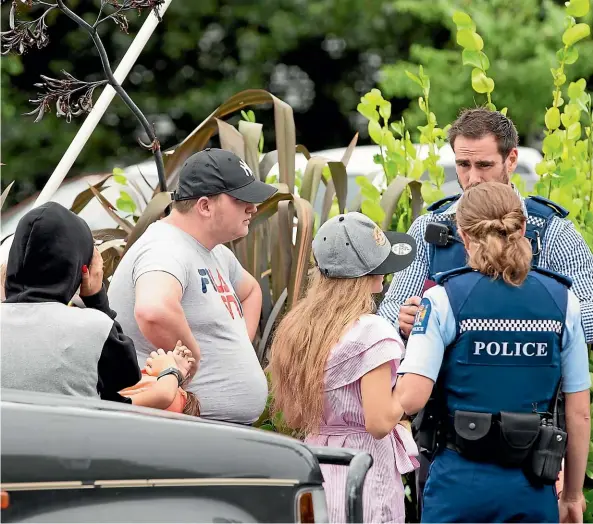  ?? TOM LEE/STUFF ?? Police talk to family members believed to be involved in an incident at Burger King, Te Rapa, Hamilton yesterday.