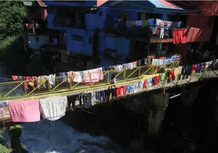  ?? Photo by Jean Nicole Cortes ?? MORE CLOTHES TO DRY. With the sun finally up on Friday, residents in StoBoSa in Km. 4 La Trinidad, Benguet maximize bridge railings for their laundry to dry.