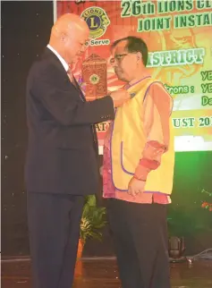  ??  ?? District governor Tiong Yong Tiing (left) presents a Lions medal to Jamit in recognitio­n of his support to the Lions Club Kapit.