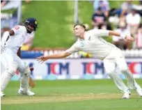  ?? Agence France-presse ?? New Zealand’s Tim Southee (right) dives to take a catch as Sri Lanka’s batsman Dimuth Karunaratn­e looks on during day one of their first Test at the Basin Reserve in Wellington on Saturday.