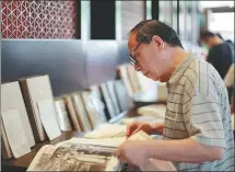  ?? DENG RUI / CHINA DAILY ?? Above: A visitor flips through a book on the history of the Qing Dynasty (1644-1911) at the site.