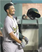  ?? RONALD MARTINEZ/GETTY IMAGES ?? A’s shortstop Marcus Semien throws his helmet in celebratio­n after homering against the Rangers in the fifth inning.