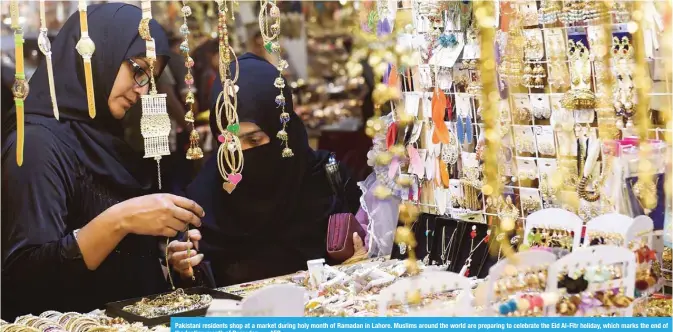  ?? — AFP ?? Pakistani residents shop at a market during holy month of Ramadan in Lahore. Muslims around the world are preparing to celebrate the Eid Al-Fitr holiday, which marks the end of the fasting month of Ramadan.