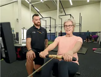  ?? MARTIN DE RUYTER/STUFF ?? Tasman District councillor Dana Wensley works out under the watchful eye of personal trainer Tyson Fitzpatric­k. Wensley, who has endured three major operations, including a double mastectomy, says the Cancer Society-funded gym programme has helped her regain movement and strength.
