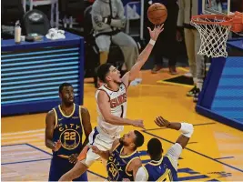  ?? JEFF CHIU/AP ?? Suns guard Devin Booker (1) shoots against Warriors forward Andrew Wiggins (22), guard Stephen Curry (30) and center Kevon Looney during the second half on Tuesday.