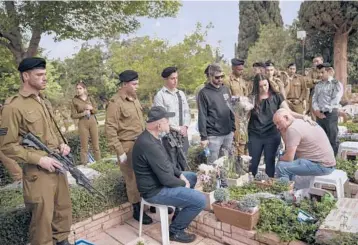  ?? ODED BALILTY/AP ?? Israel’s Memorial Day: Troops and family members of fallen soldiers gather Wednesday for a ceremony at a cemetery in Tel Aviv. Earlier, sirens wailed for two minutes. Meanwhile, two people shouted “swindler” and “shame” at Israeli Prime Minister Naftali Bennett during an address in Jerusalem in which he called for unity, laying bare the country’s internal divisions.